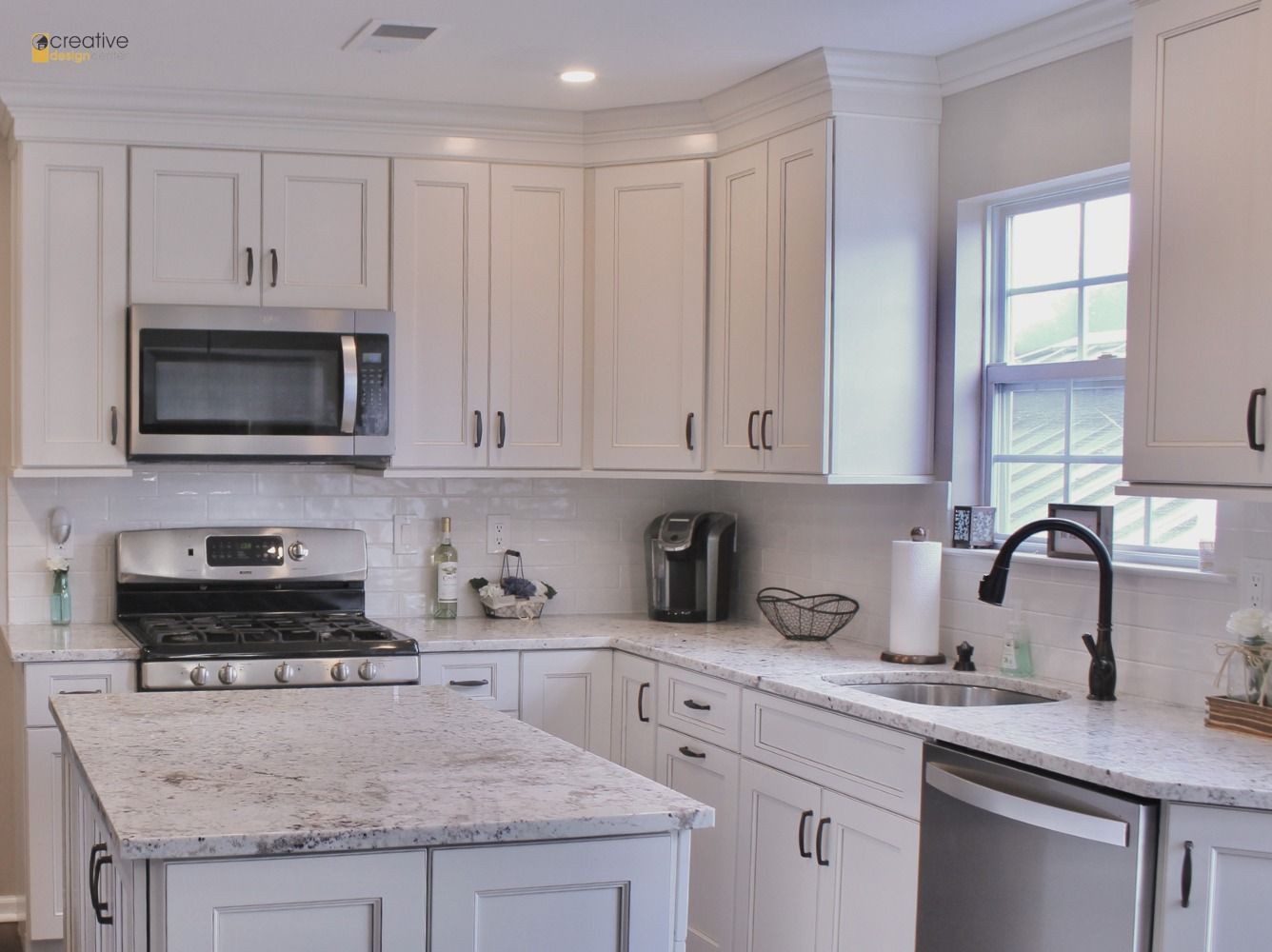 A kitchen with white cabinets and granite counter tops.