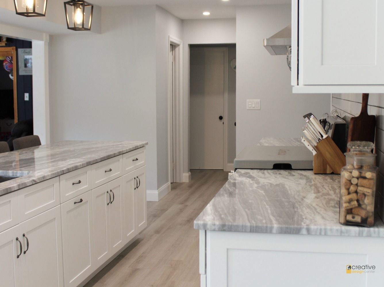 A kitchen with white cabinets and granite counter tops.