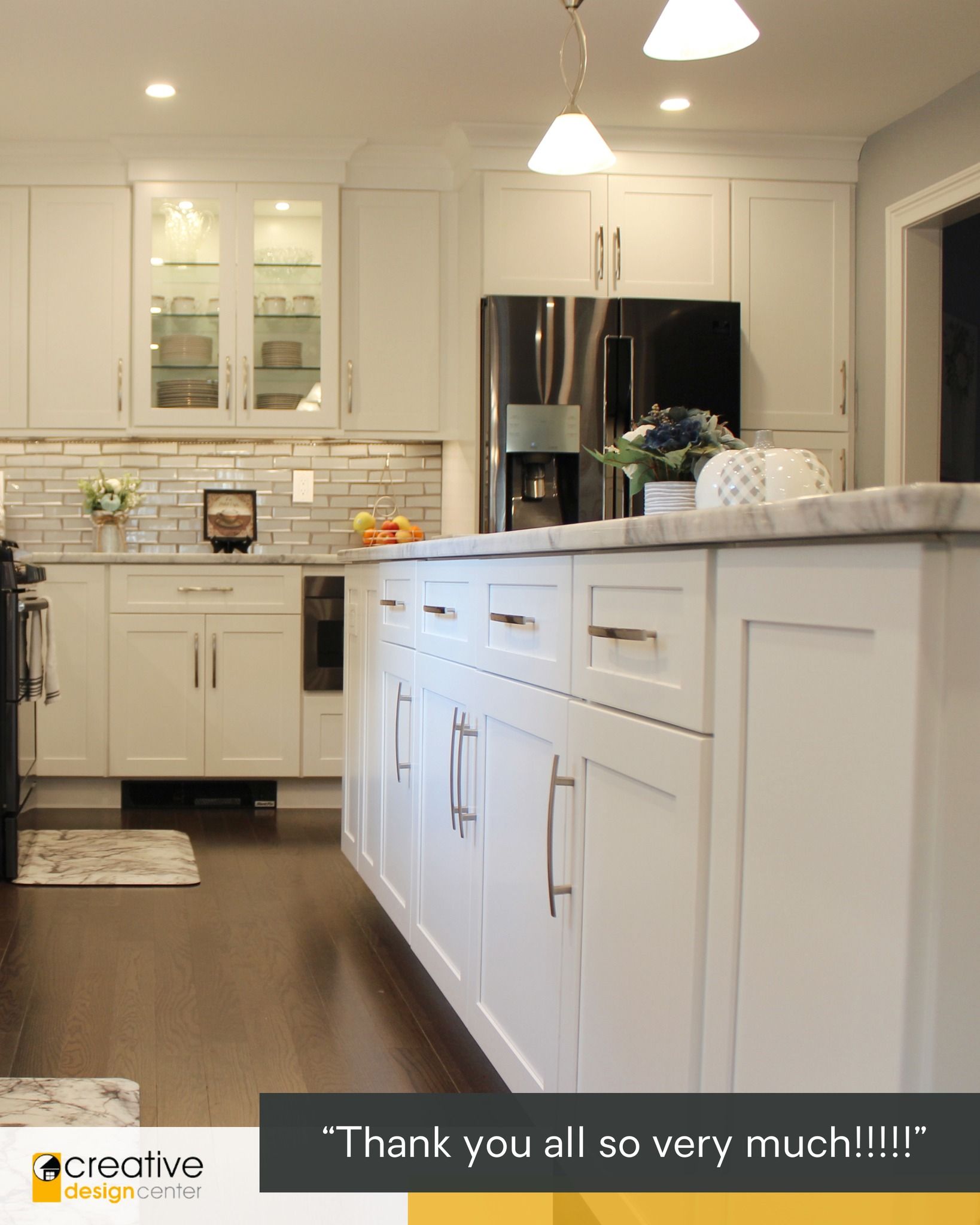 A kitchen with white cabinets and a marble counter top.