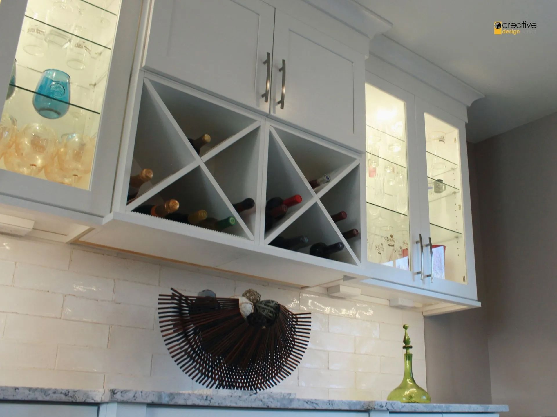 A kitchen with white cabinets and a wine rack