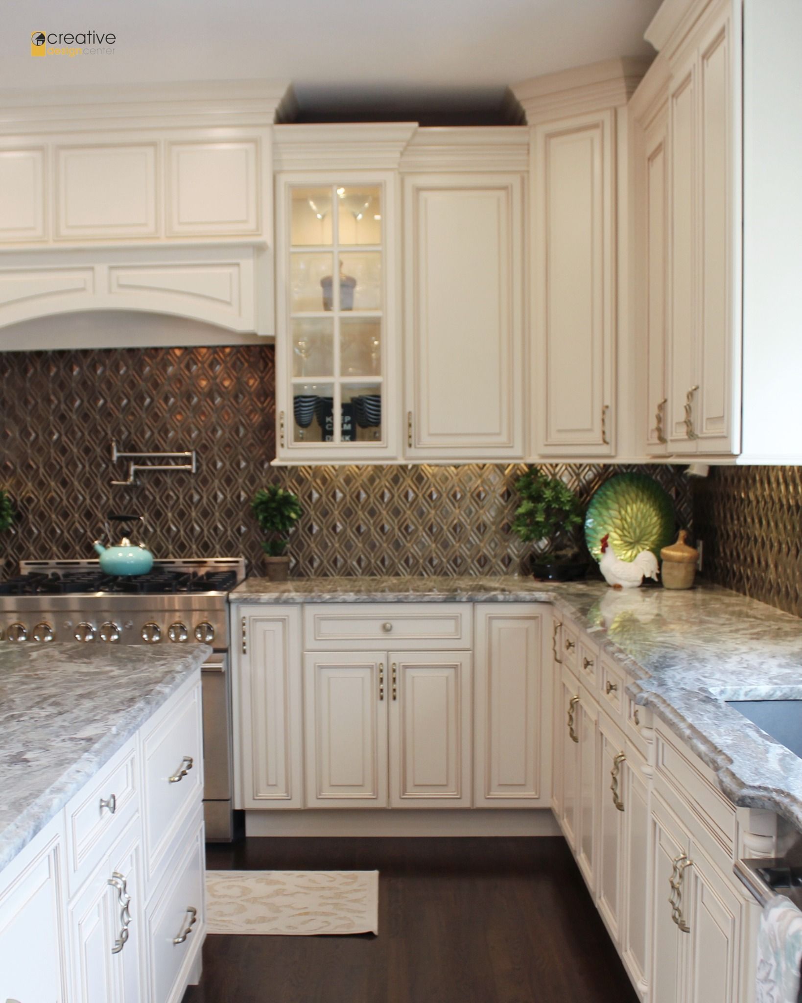 A kitchen with white cabinets and granite counter tops.