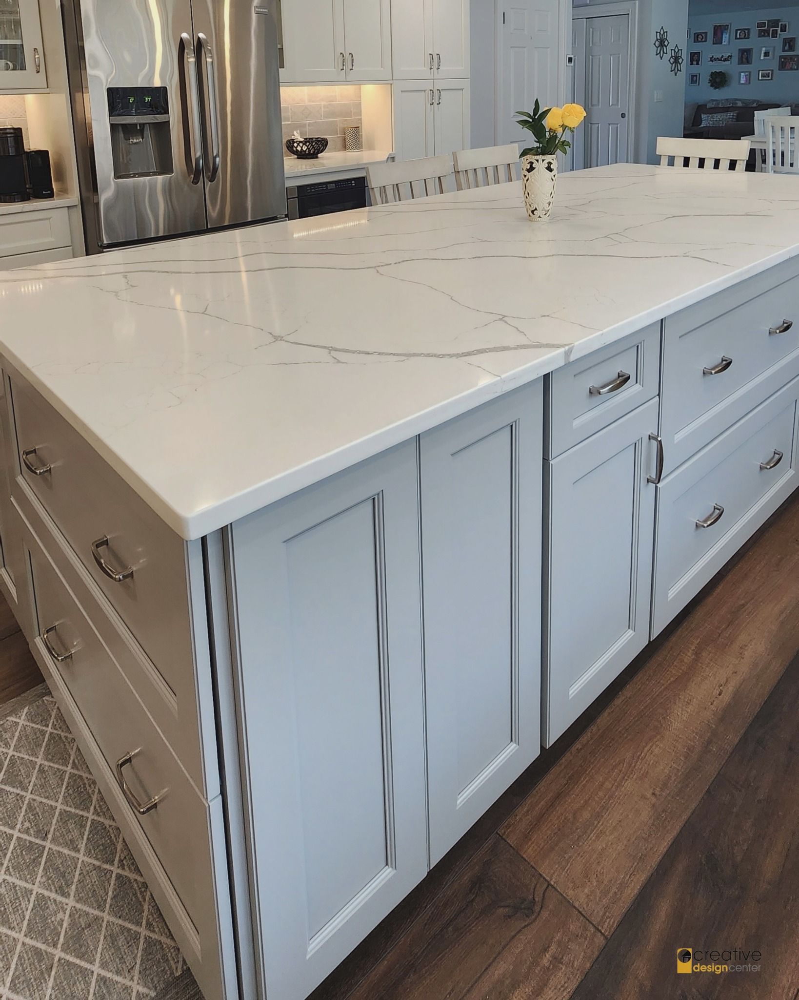 A kitchen with white cabinets and white counter tops.