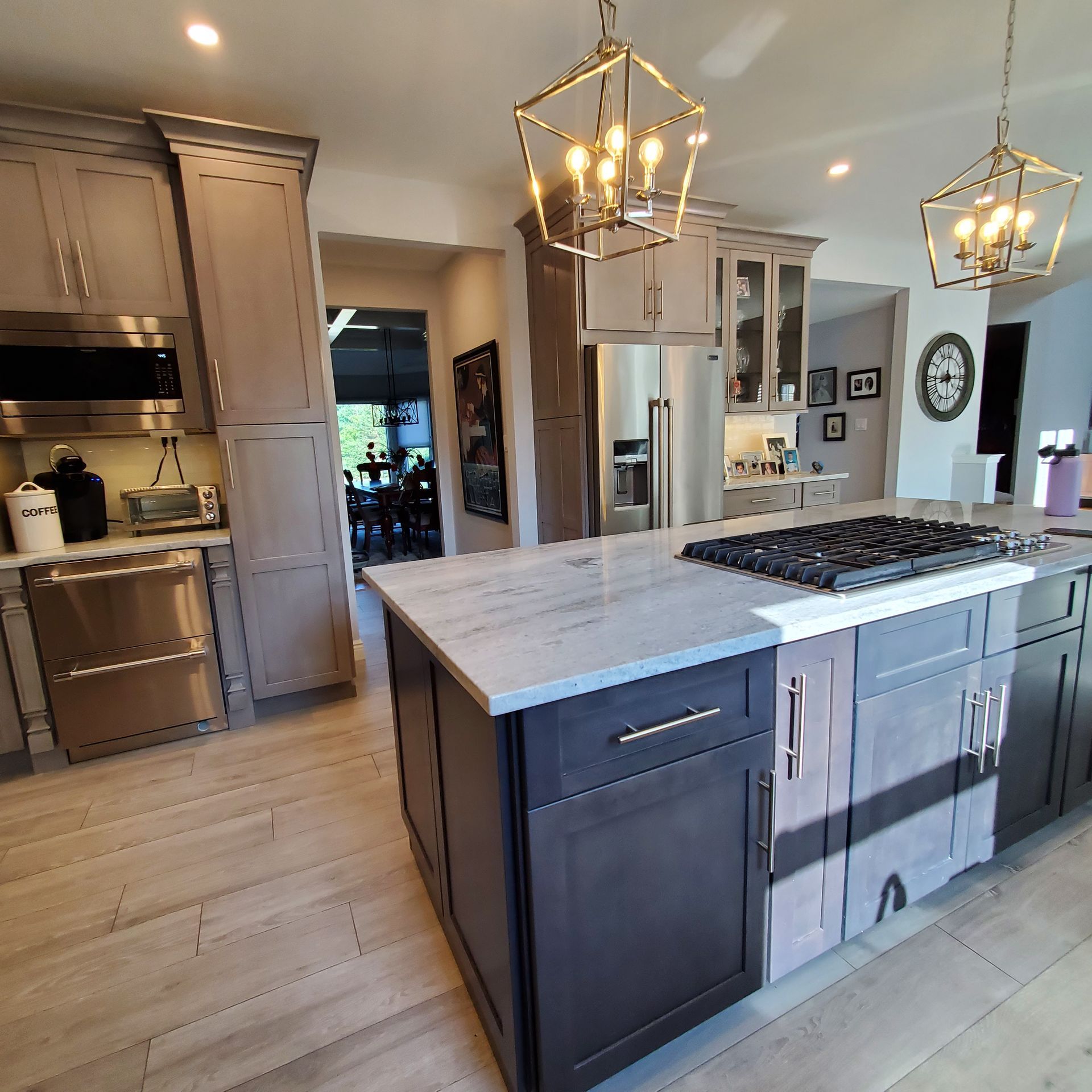Modern kitchen with an island, stainless steel appliances, and pendant lighting.