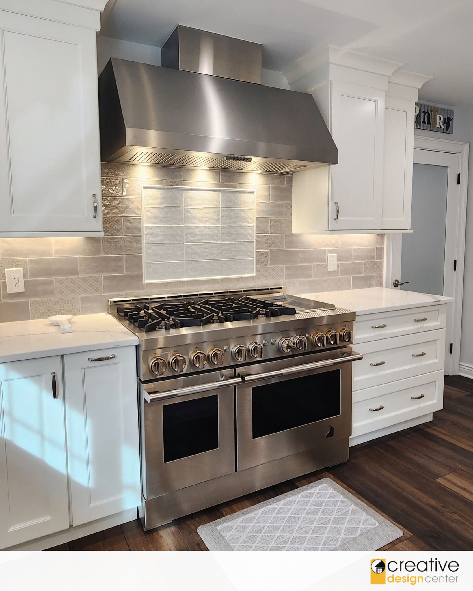 A kitchen with stainless steel appliances and white cabinets.