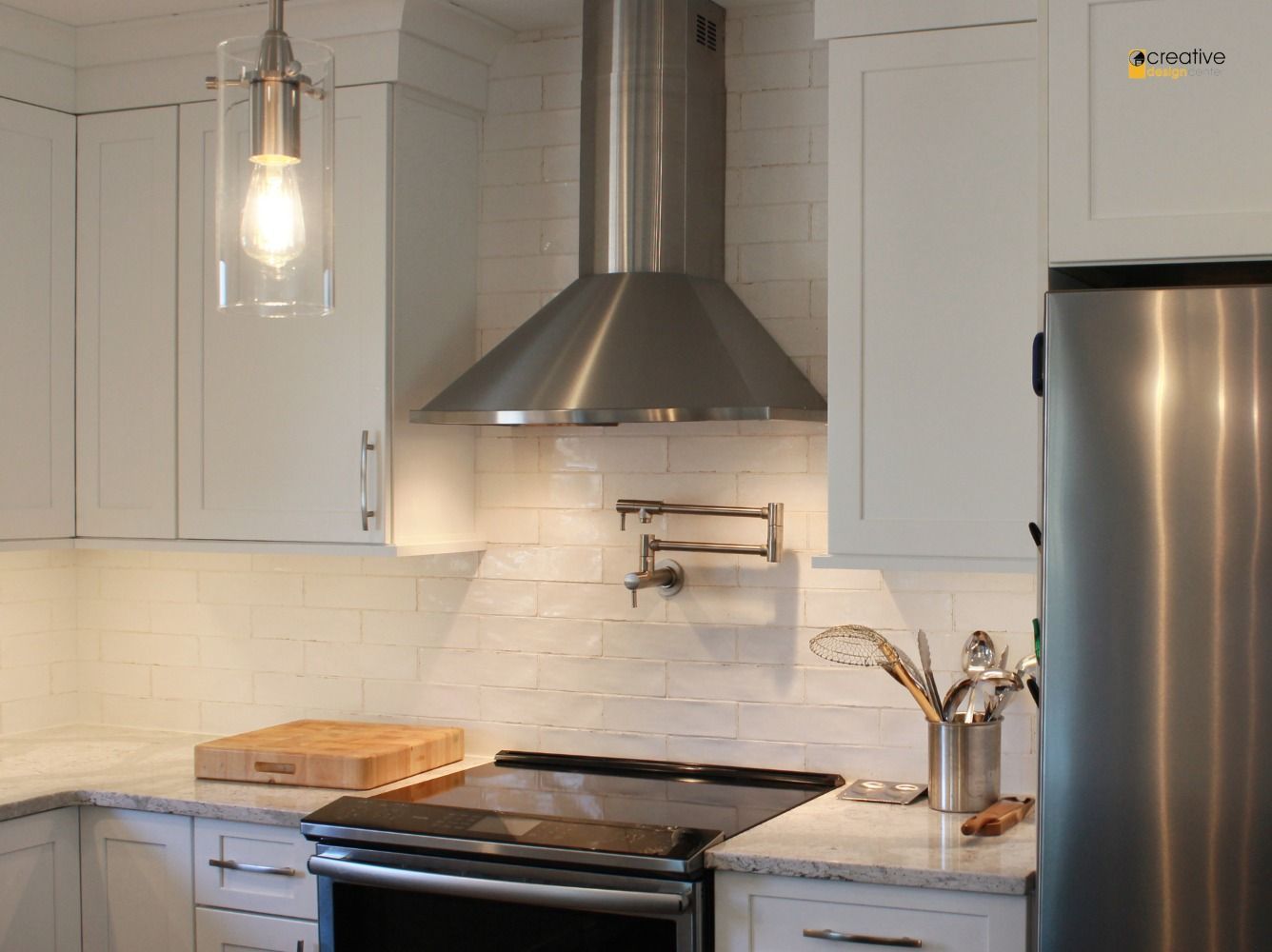 A kitchen with stainless steel appliances and white cabinets.