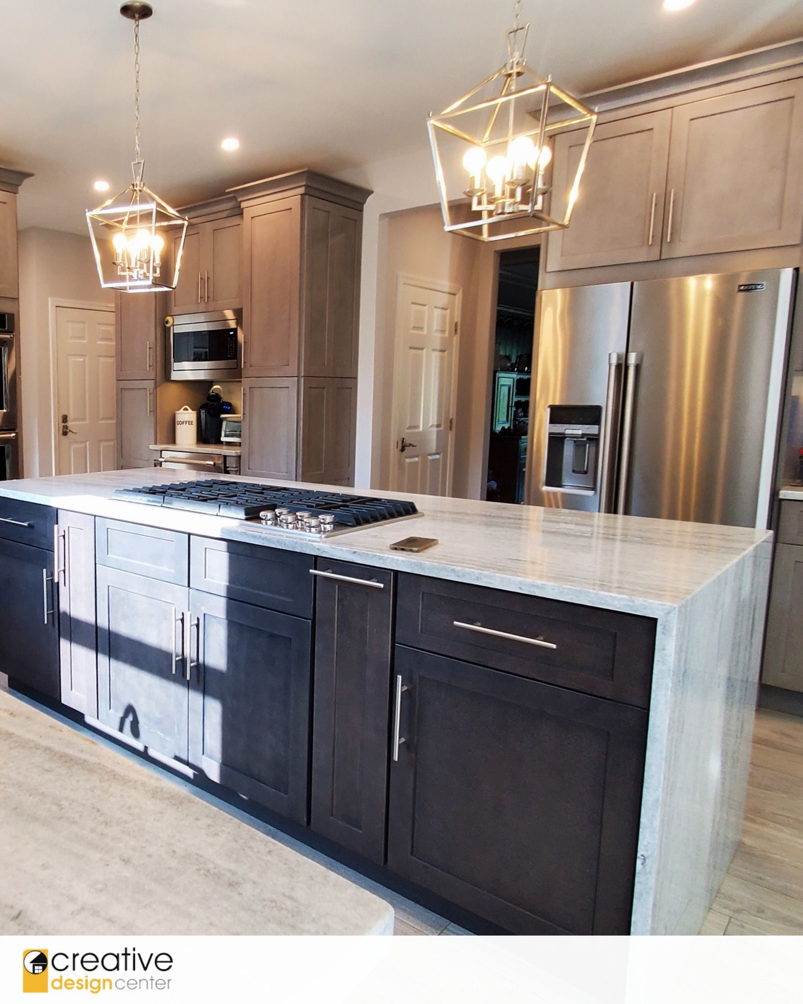 A kitchen with a large island and stainless steel appliances.