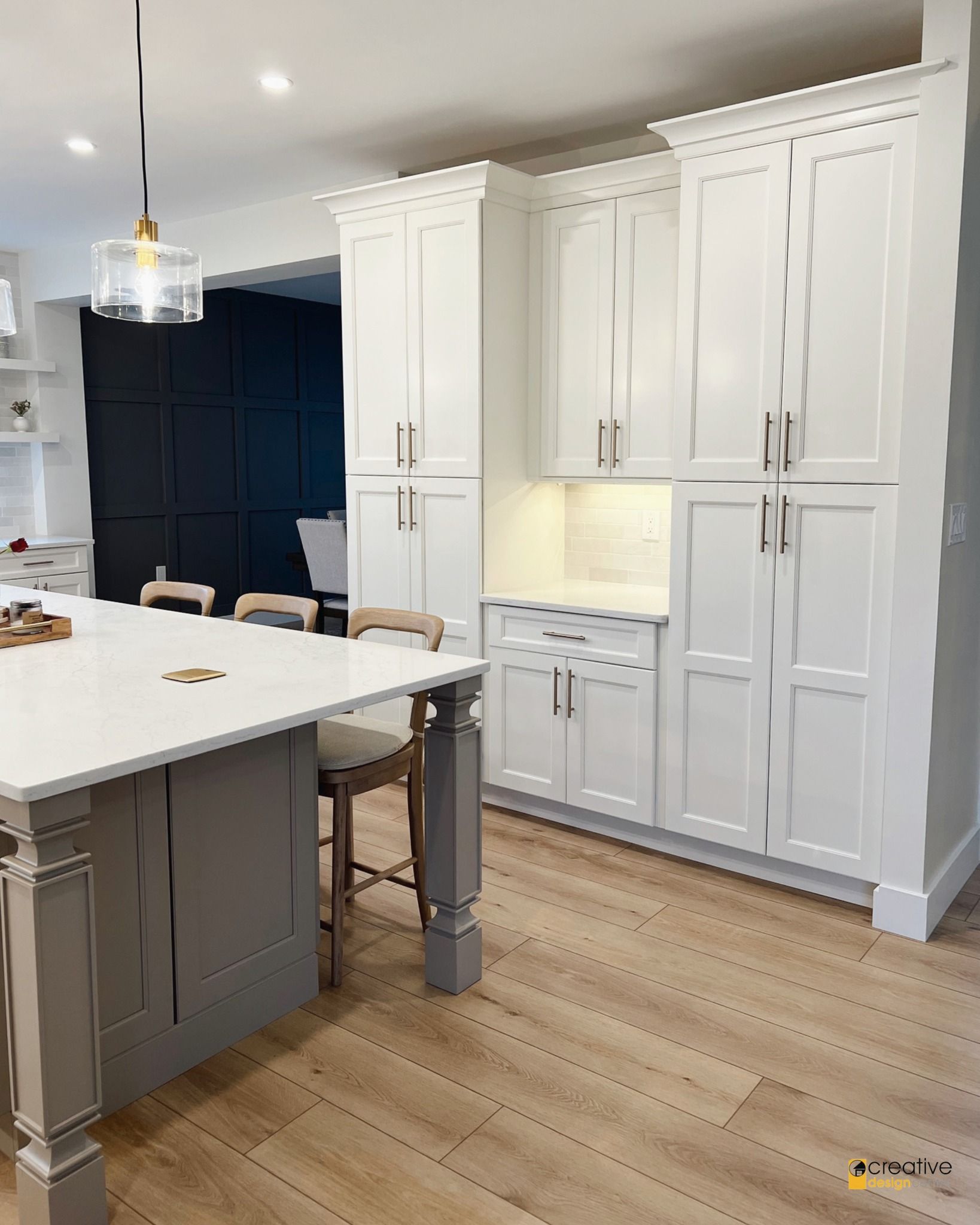 A kitchen with white cabinets and a large island.