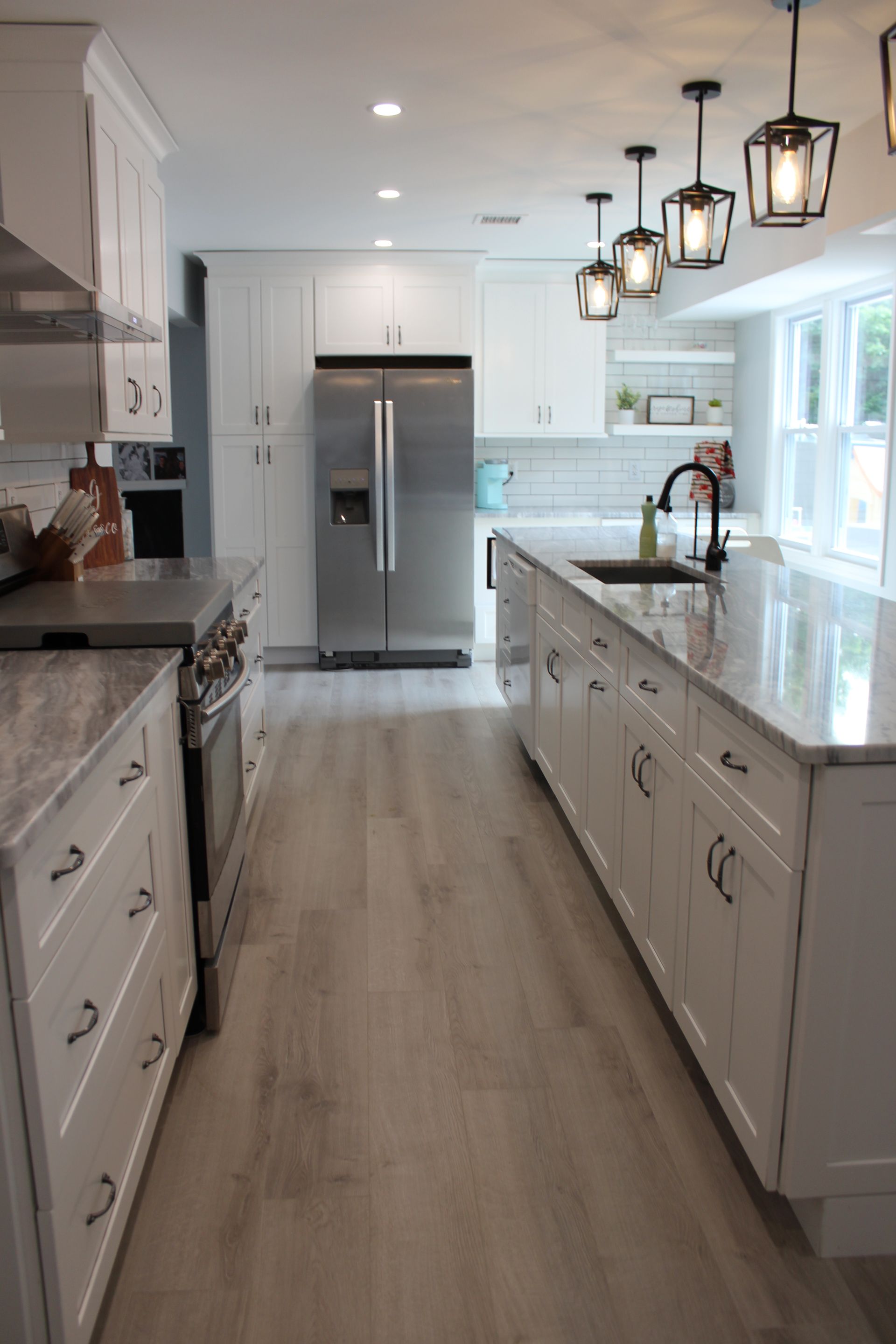 Stainless steel microwave built into a white cabinet.