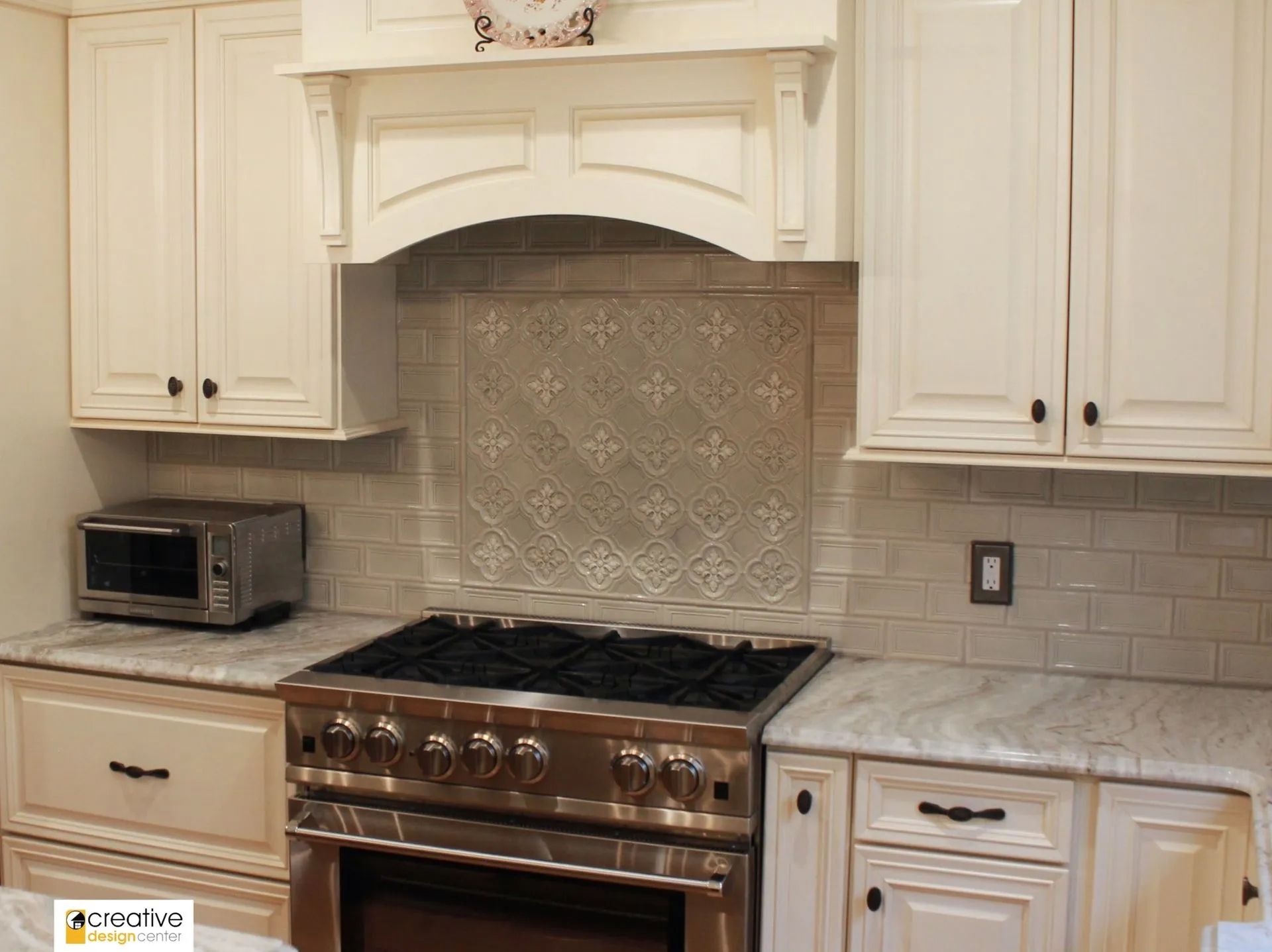 A kitchen with stainless steel appliances and white cabinets.