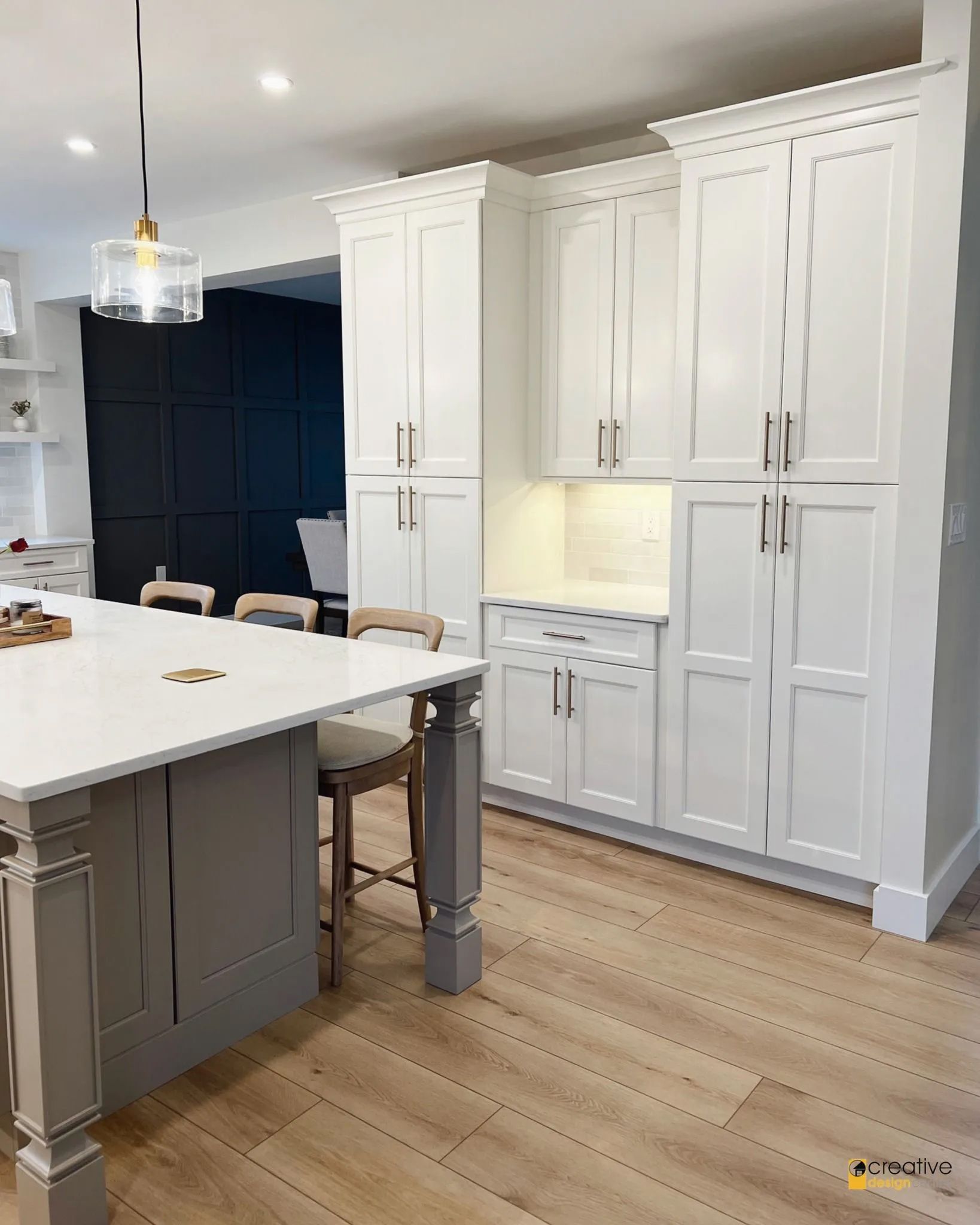 A kitchen with white cabinets and a large island.