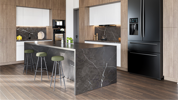 Modern kitchen with a black marble island and dark refrigerator, wooden cabinets, and green stools.