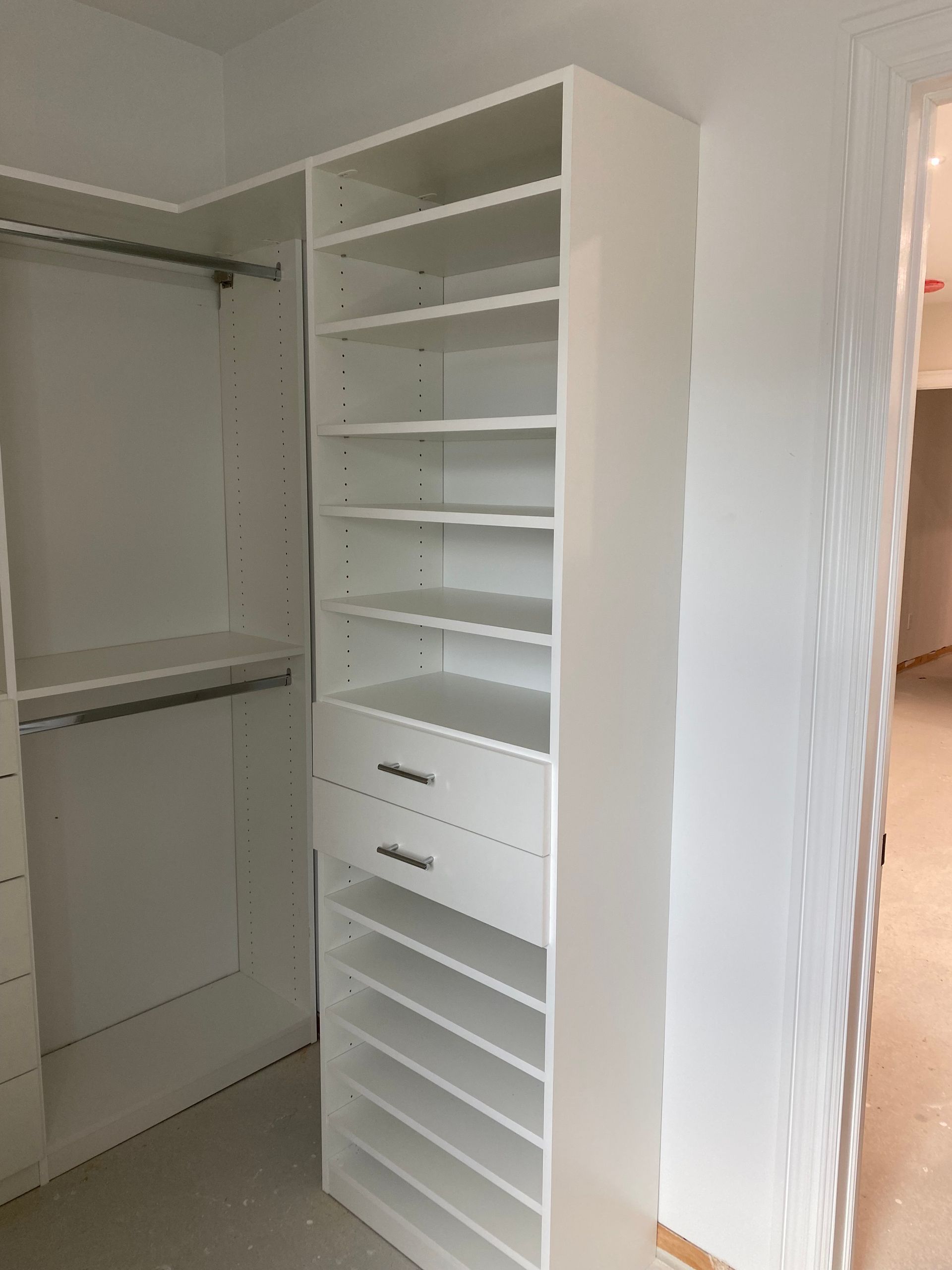 White closet organizers with shelves and drawers.