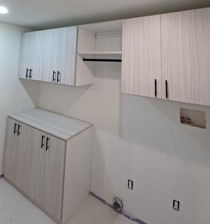 Laundry room with light wood cabinets, open shelving, and a hanging rod.