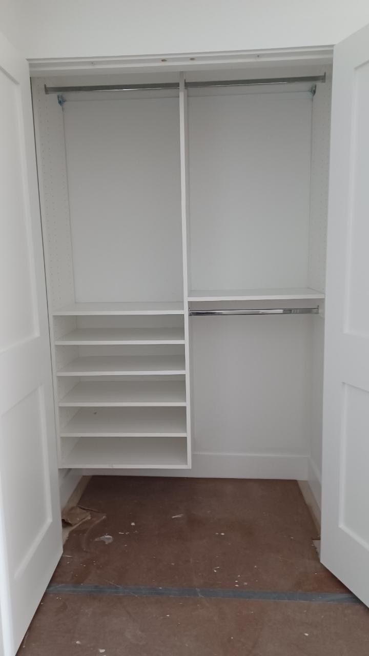 White closet interior with shelves, a lower rod, and two upper rods. Doors are open.