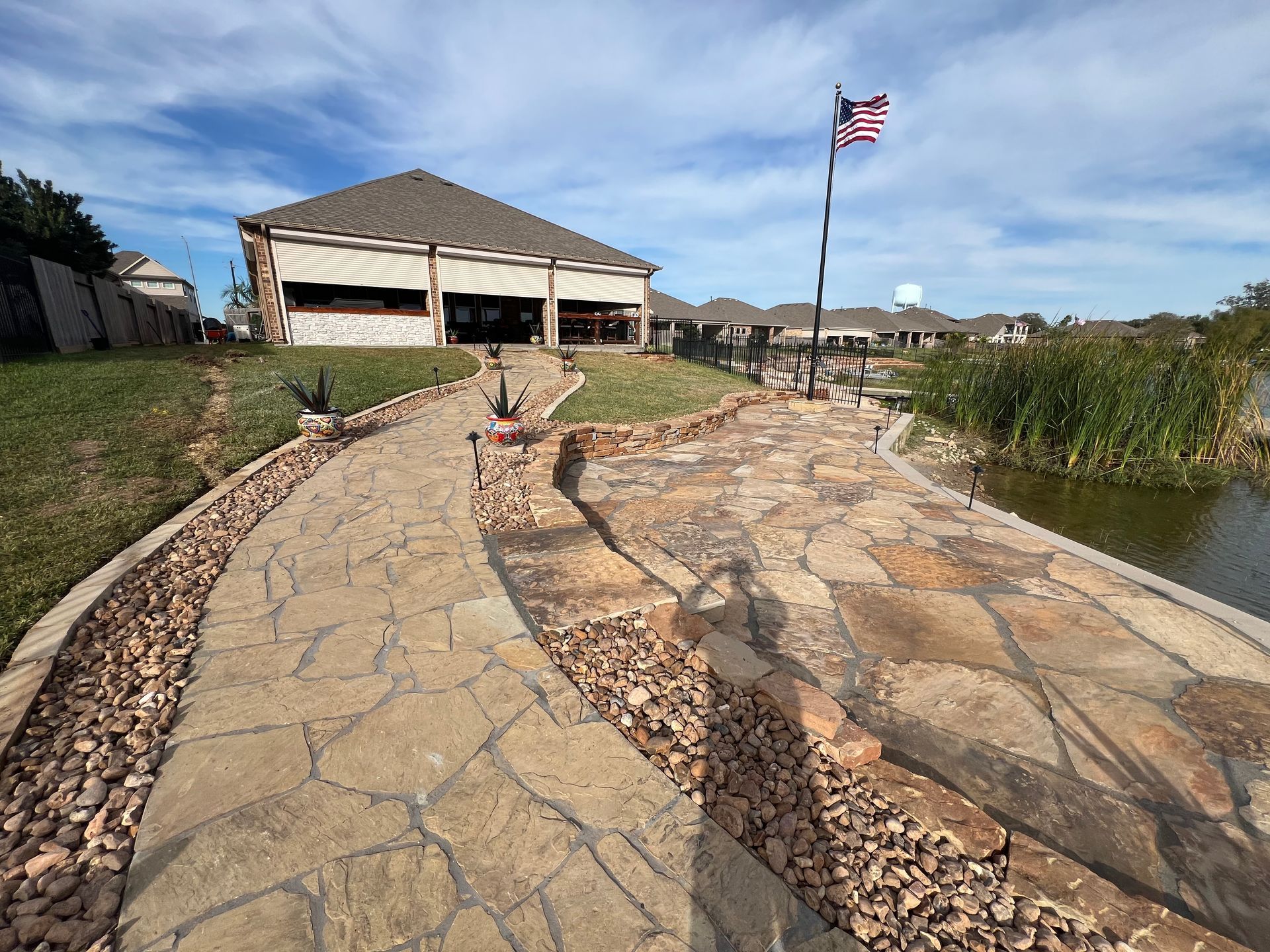 Stone walkway leading to a pavilion and American flag under a blue sky