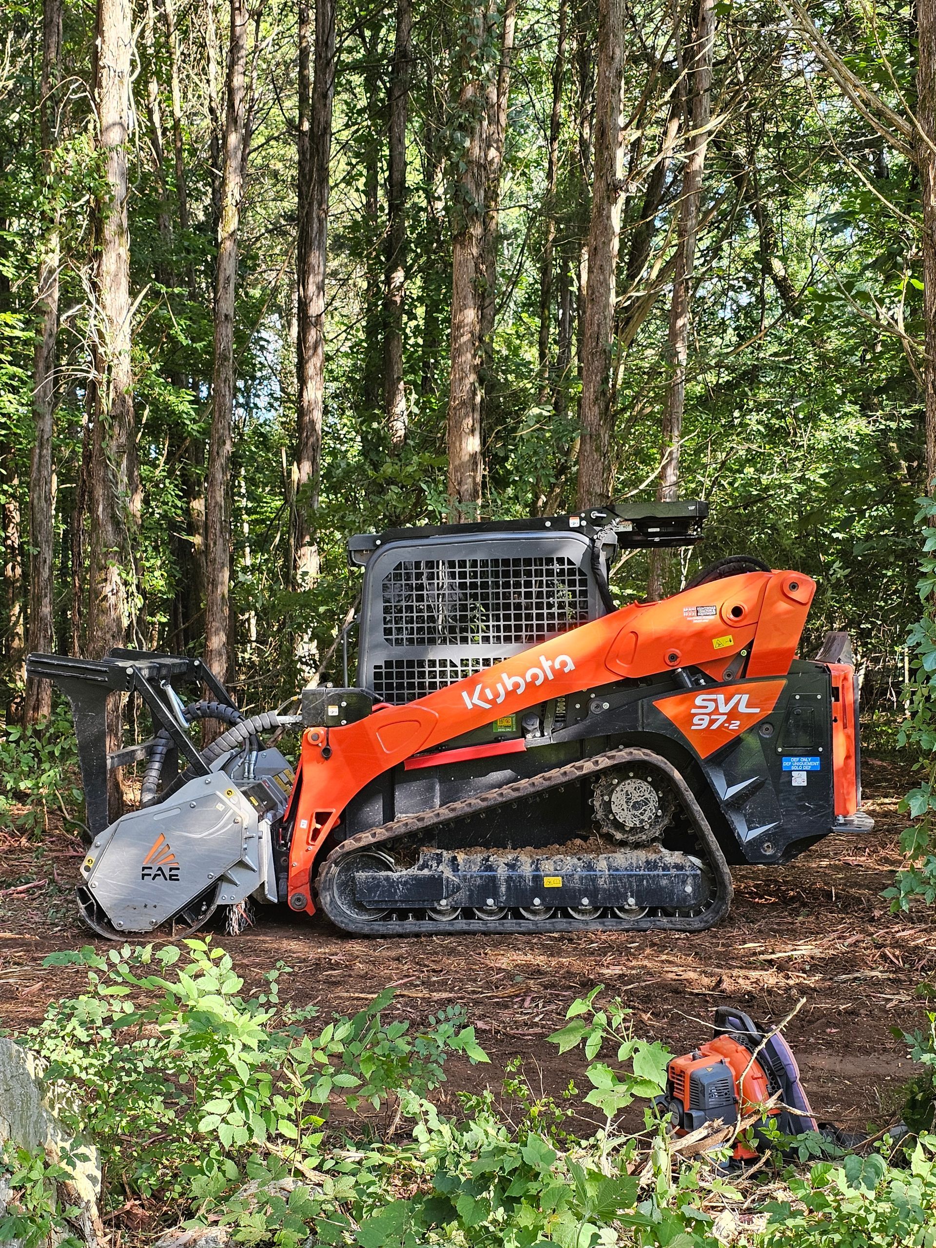 A bulldozer is sitting in the middle of a forest.