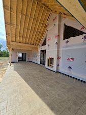 Construction site of a house with exposed wood beams and white weather-resistant wrap