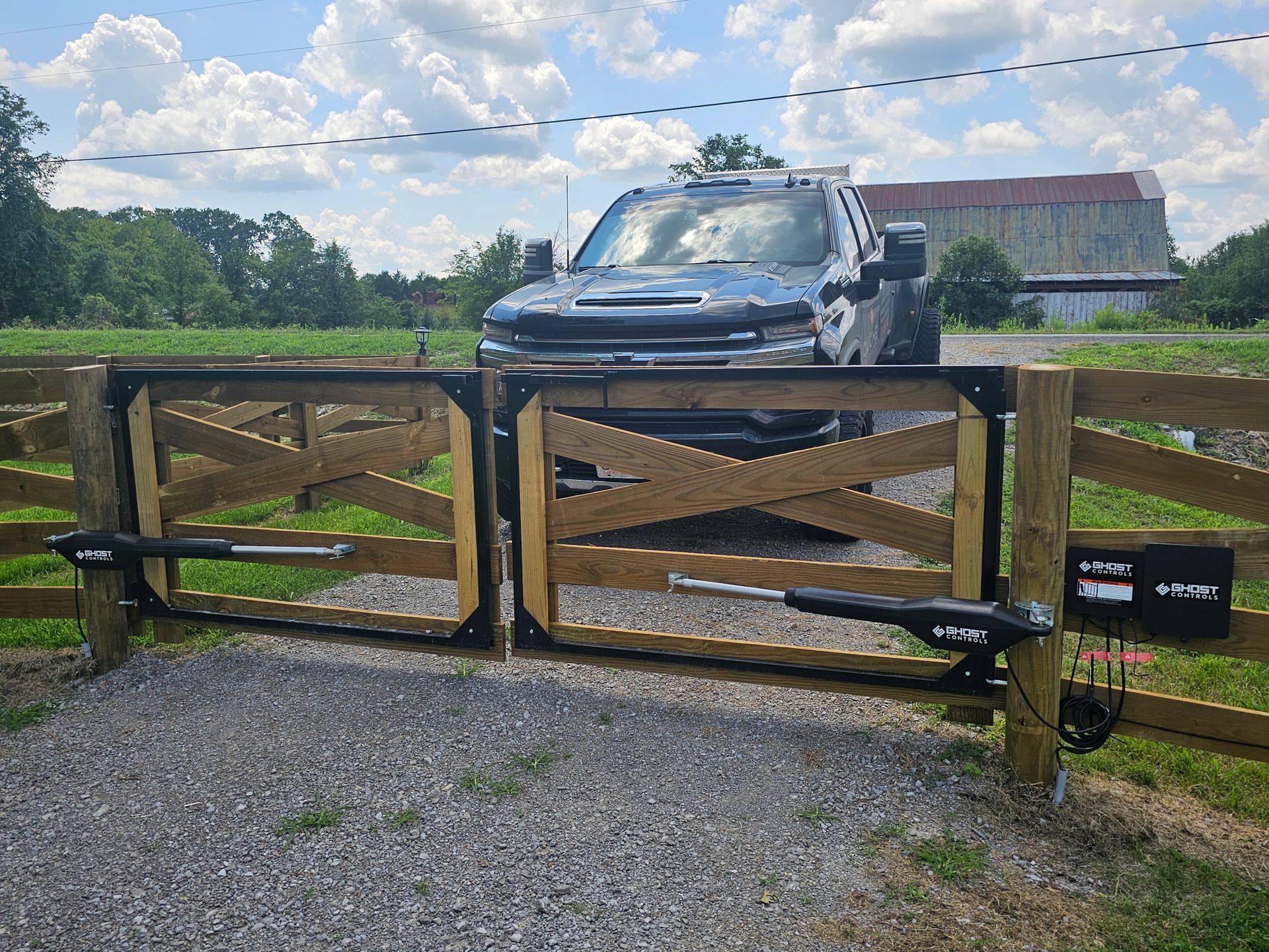 A truck is parked behind a wooden gate.