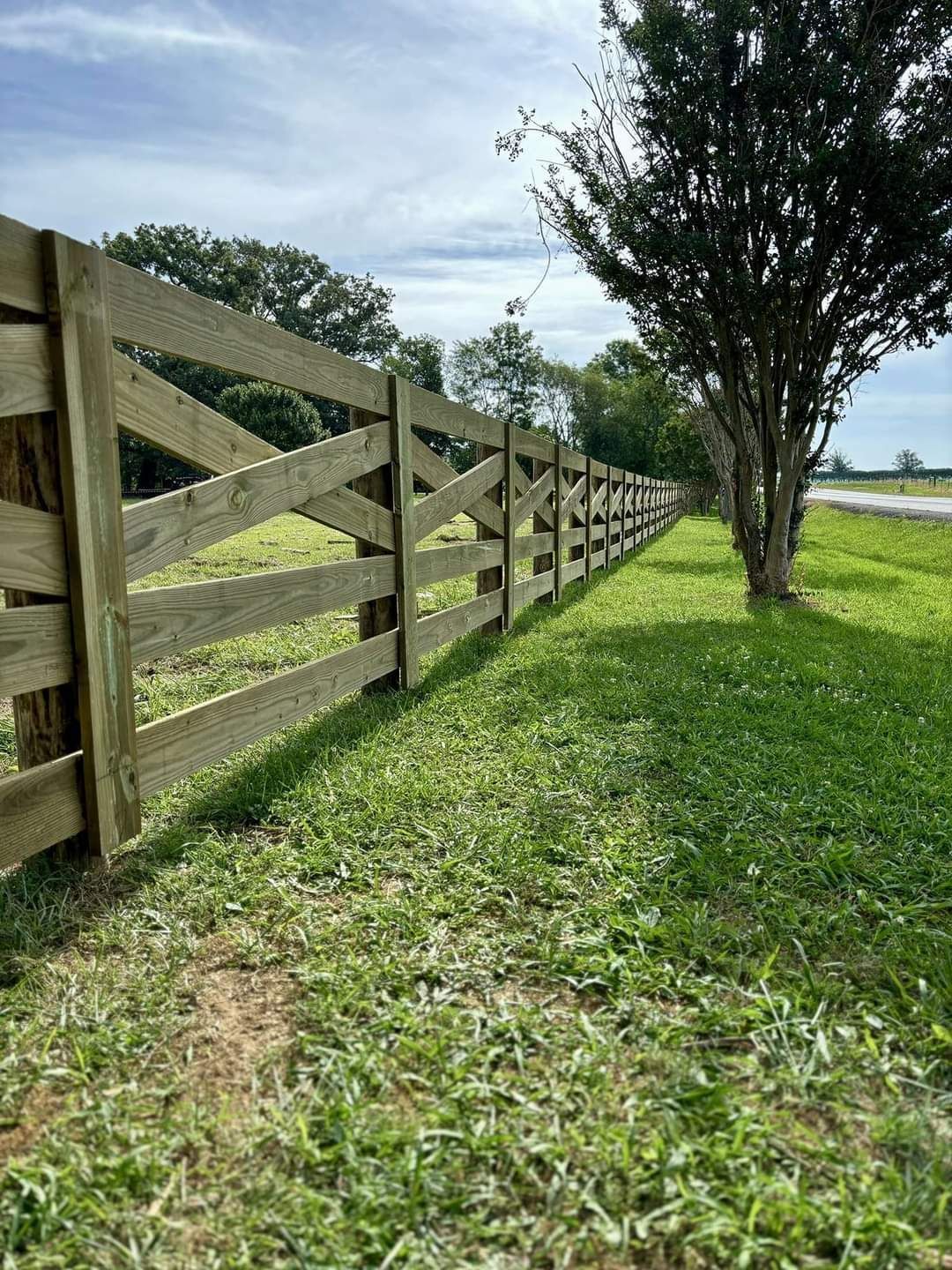 A wooden fence is sitting in the middle of a grassy field.
