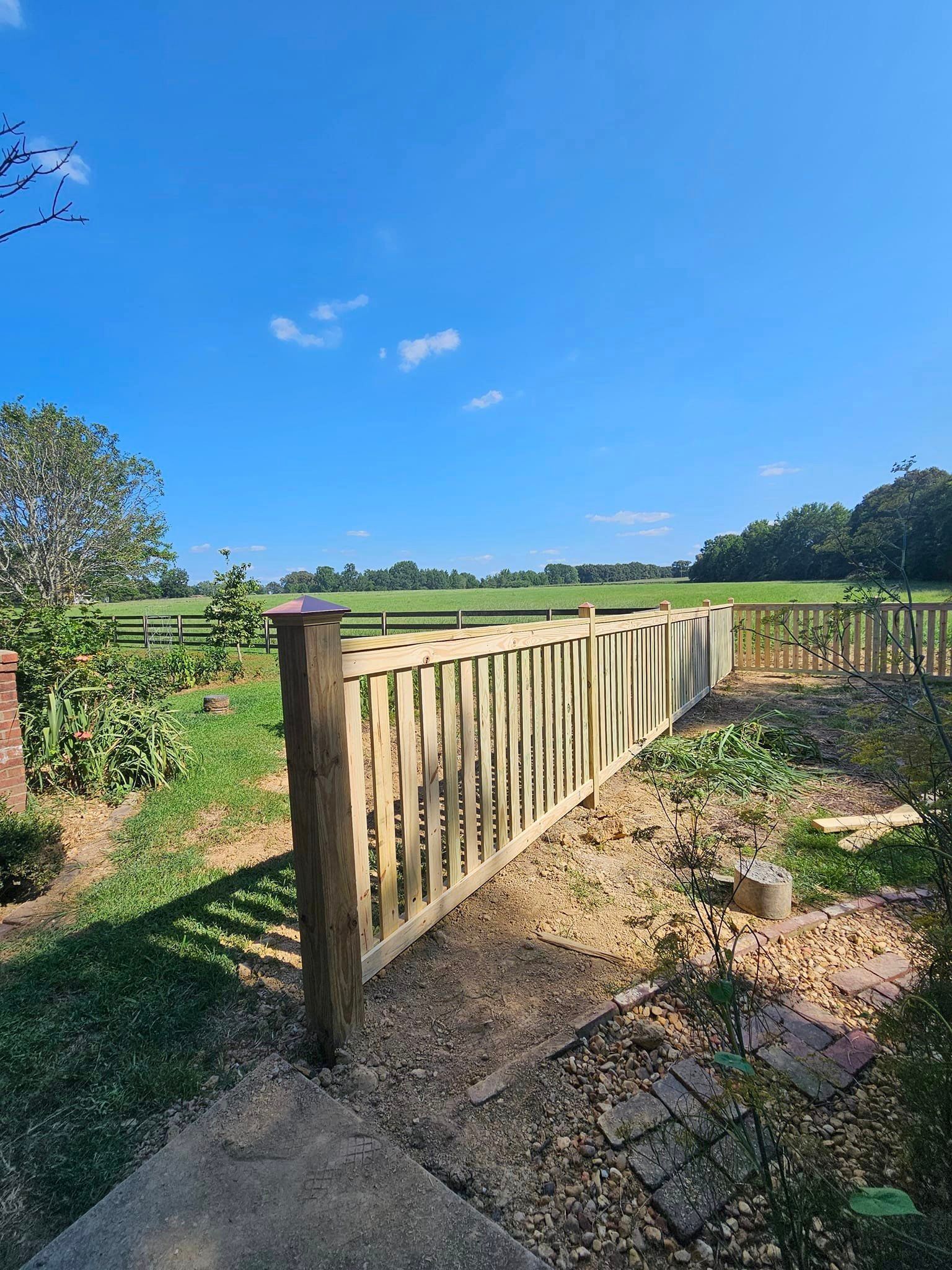 A wooden fence is sitting in the middle of a field.