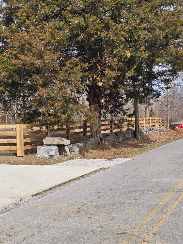There is a wooden fence along the side of the road.