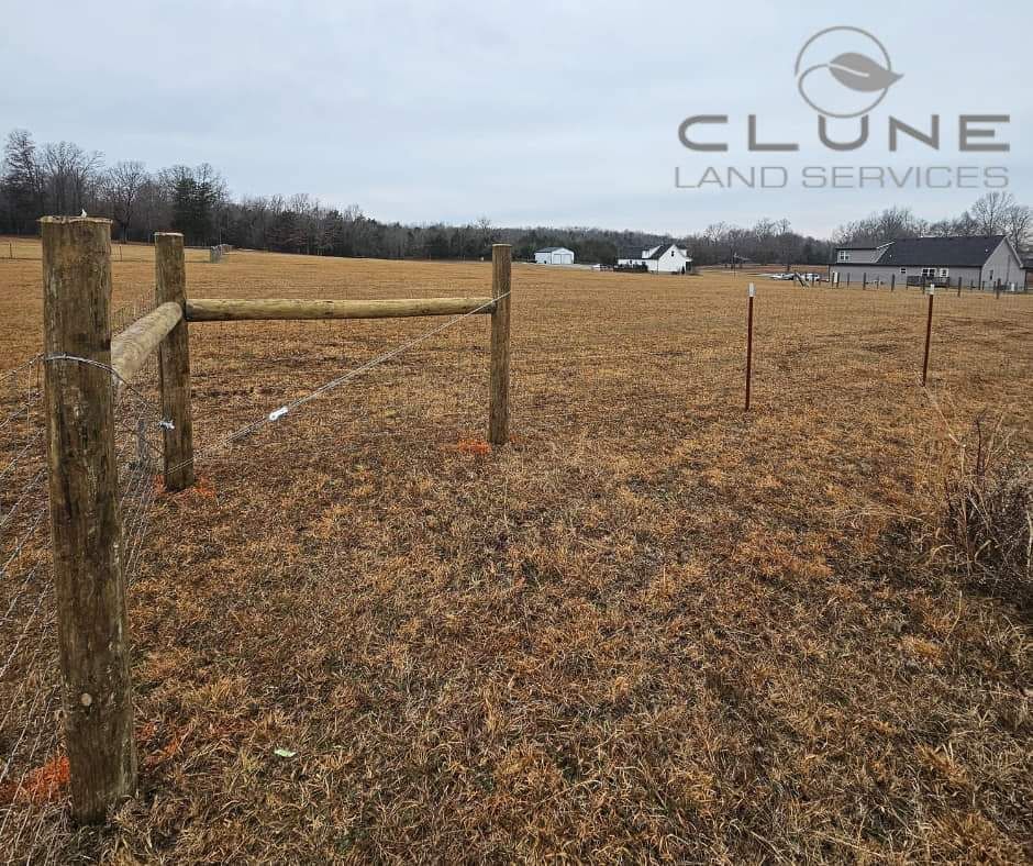 A wooden fence in a field that is owned by clunie land services