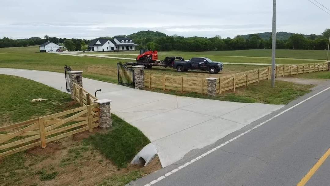 A truck is driving down a road next to a wooden fence.