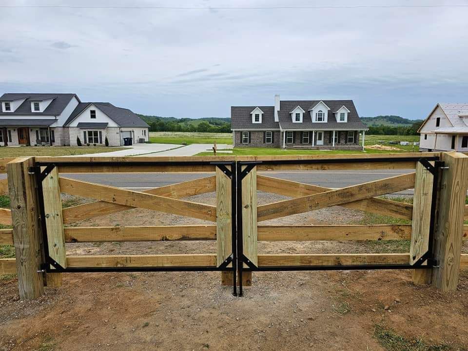 A wooden fence with a gate in front of a row of houses.