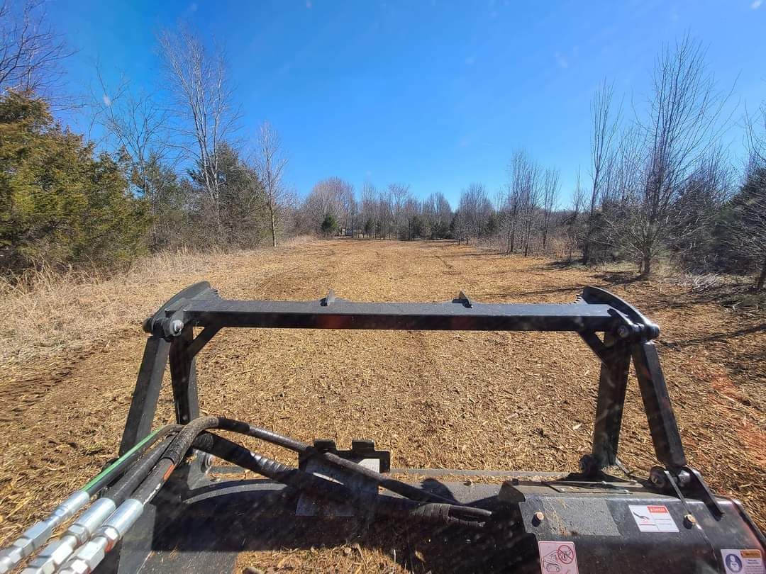 A person is driving a tractor through a field.