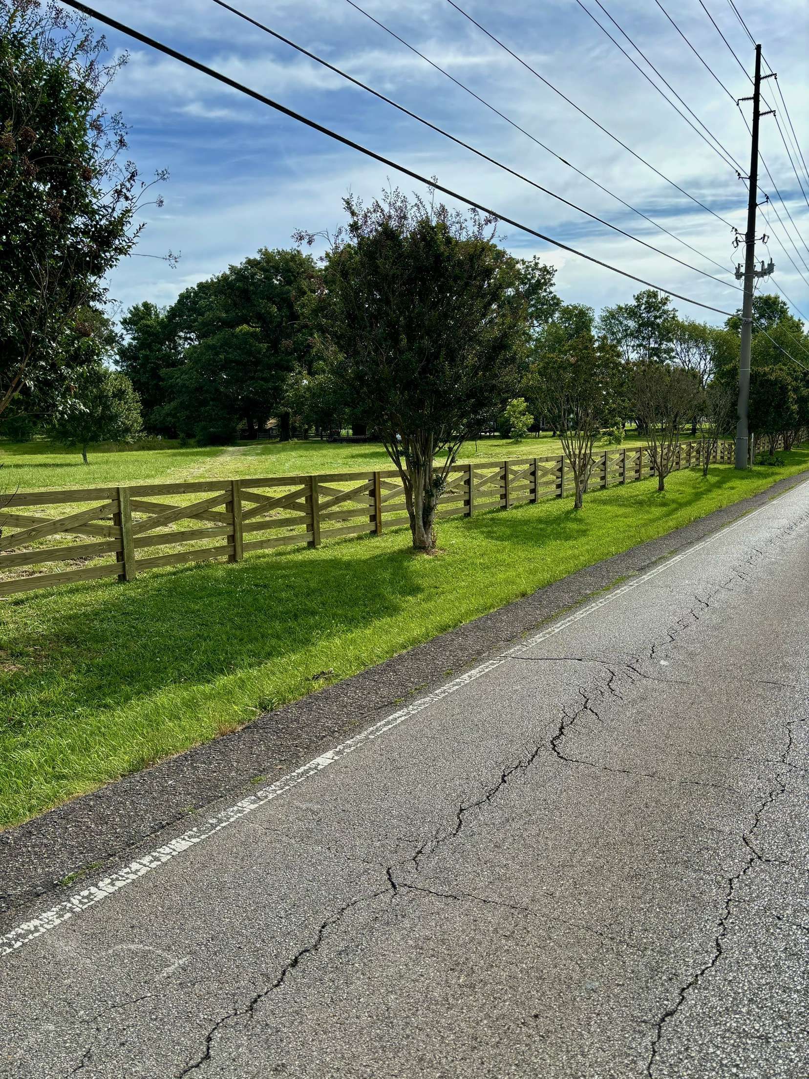 There is a wooden fence along the side of the road.