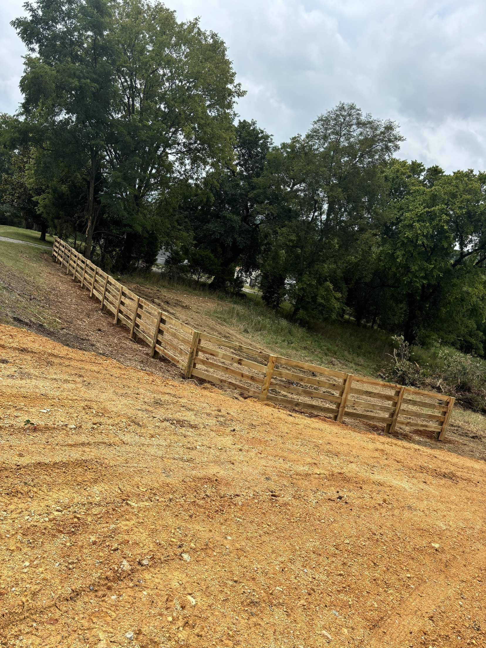 There is a wooden fence in the middle of a field.