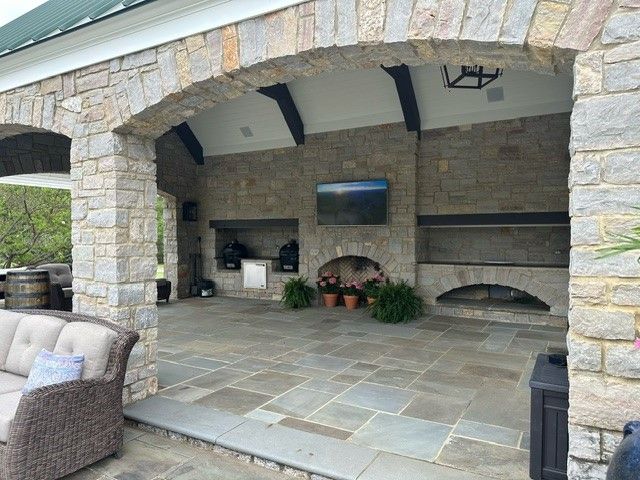 An outdoor stone patio with a TV