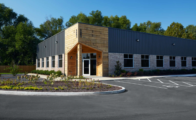 A large building with a lot of windows and a parking lot in front of it