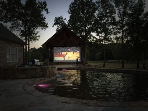 A basketball game is being played on a large screen.