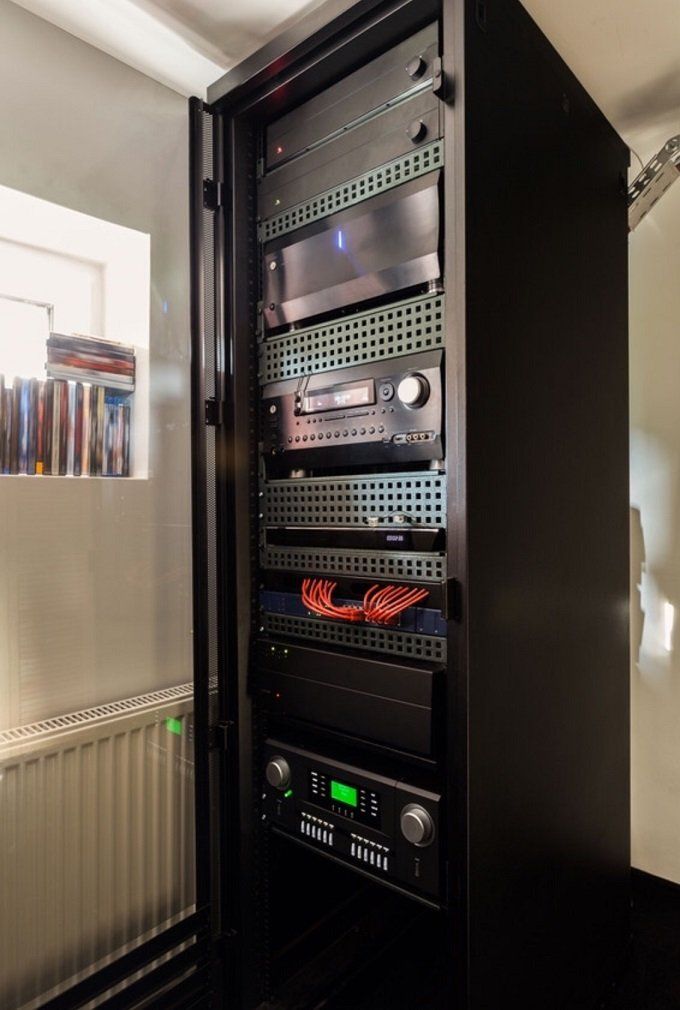 A rack with a lot of electronics on it in a room