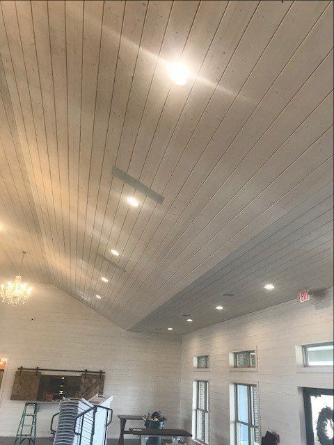 A large room with a wooden ceiling and lots of windows