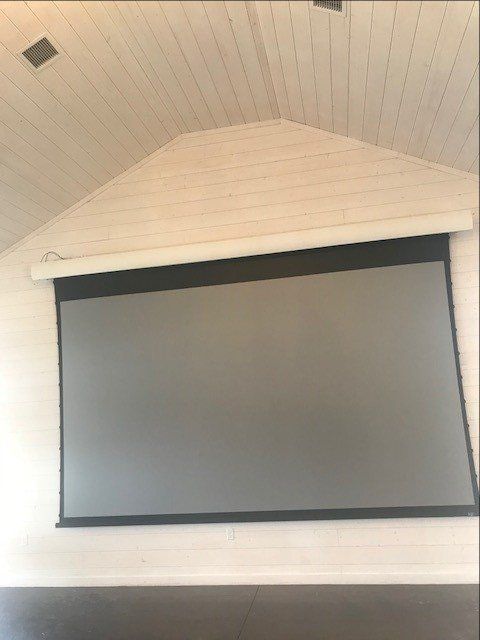 A projector screen is hanging from the ceiling in a room