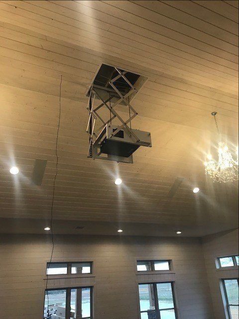 A large room with a projector hanging from the ceiling