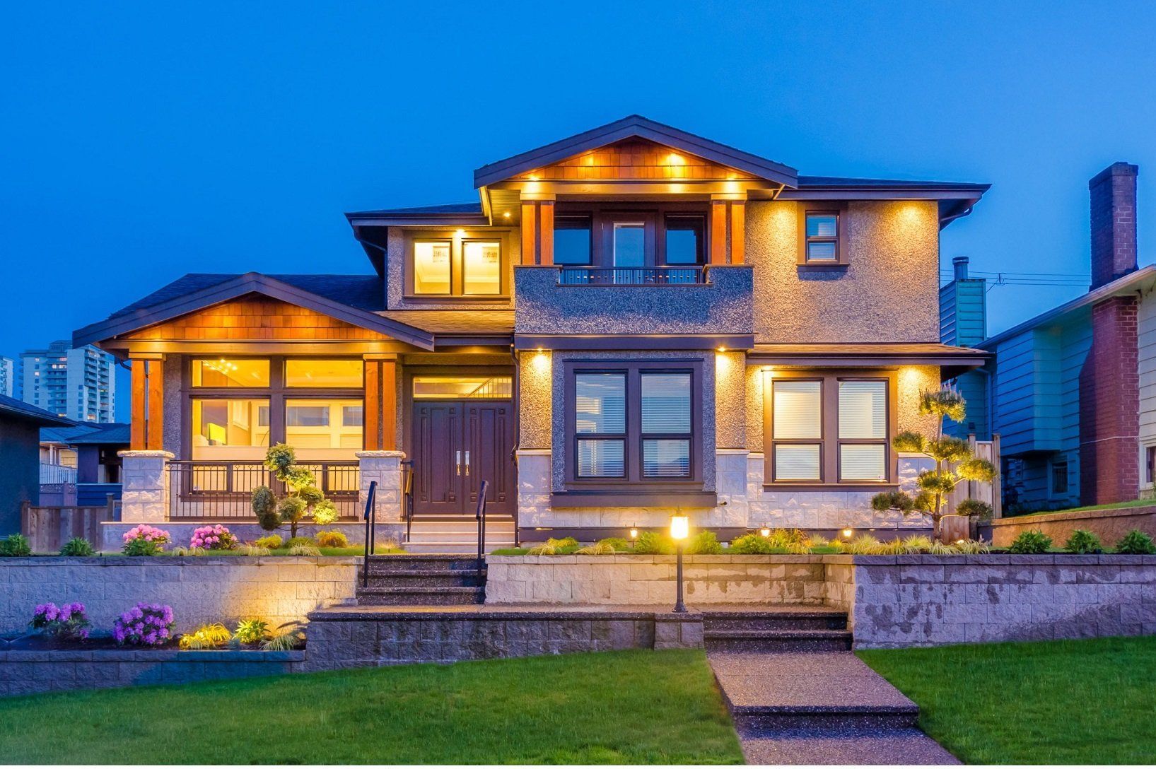 A large house with a lot of windows is lit up at night