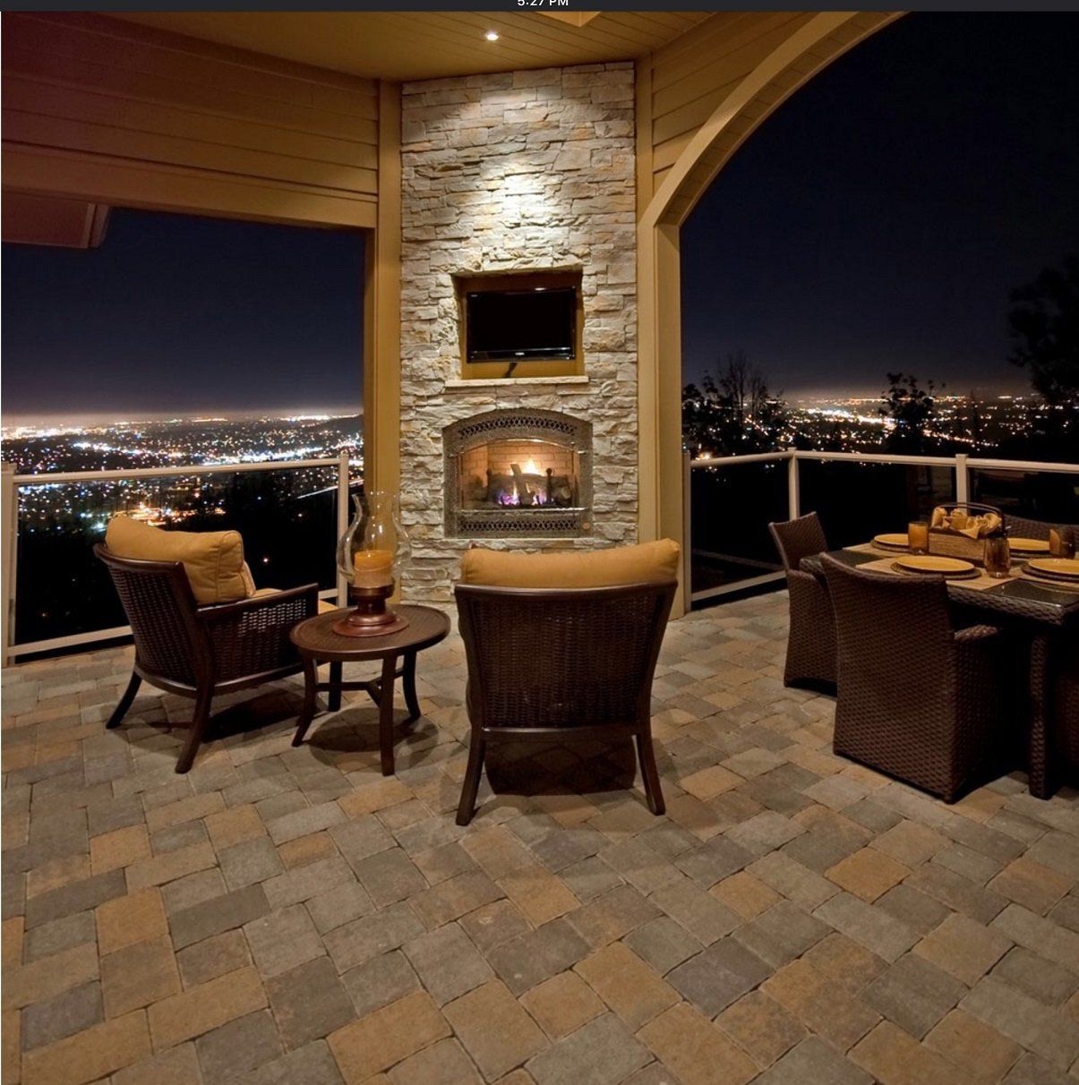 A patio with a fireplace and chairs at night