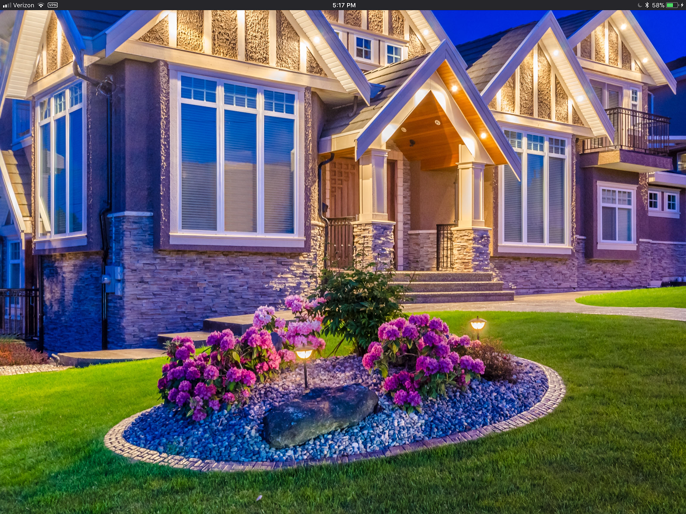 A large house with purple flowers in front of it