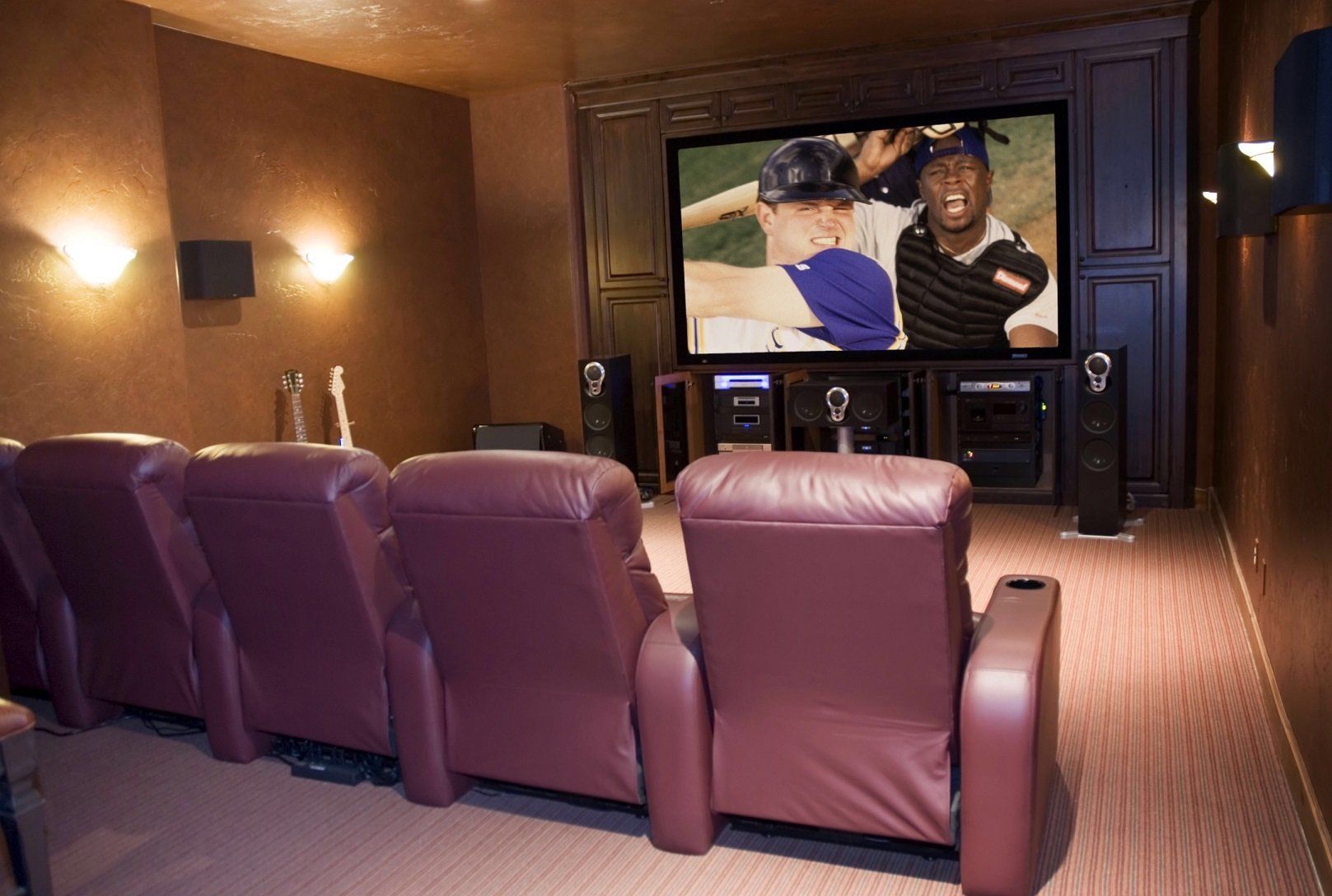 A home theater with purple leather seats and a large screen