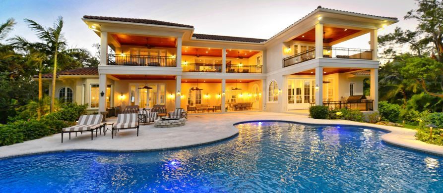 A large house with a swimming pool in front of it