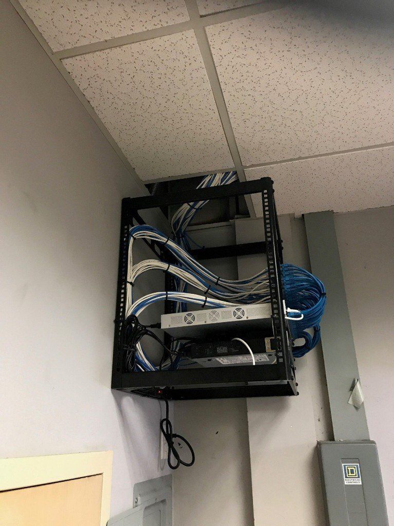 A rack with a lot of wires hanging from the ceiling