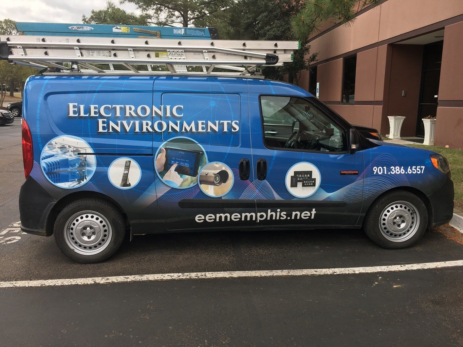 A blue van for electronic environments is parked in a parking lot