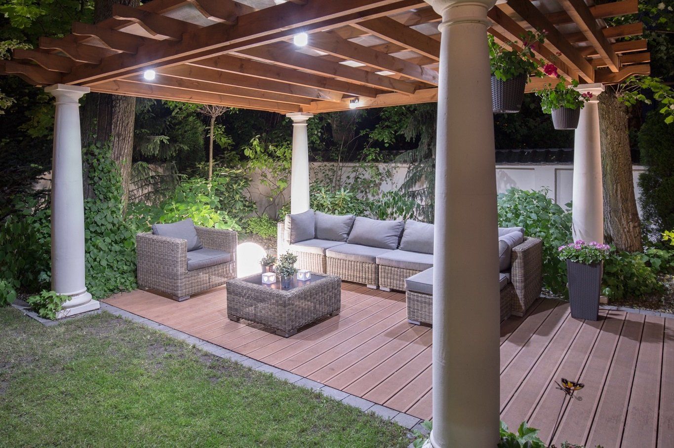 There is a pergola with a couch and chairs underneath it