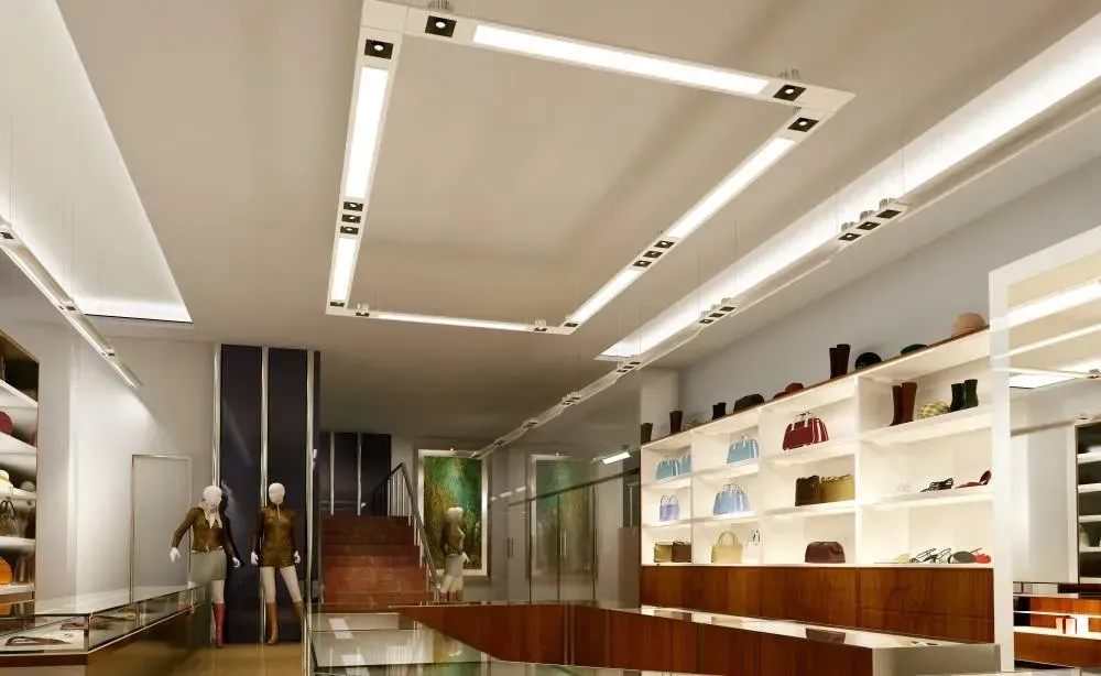 Modern boutique interior with white shelving, wooden counter, and recessed ceiling lights