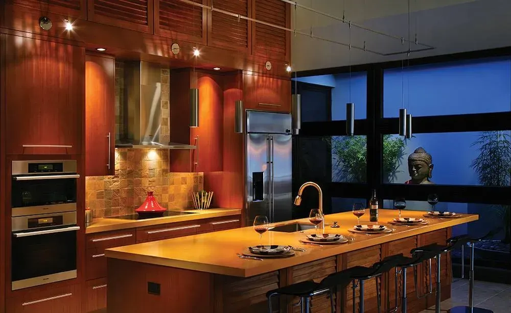 Modern kitchen with a large wooden island, pendant lights, and stainless steel appliances