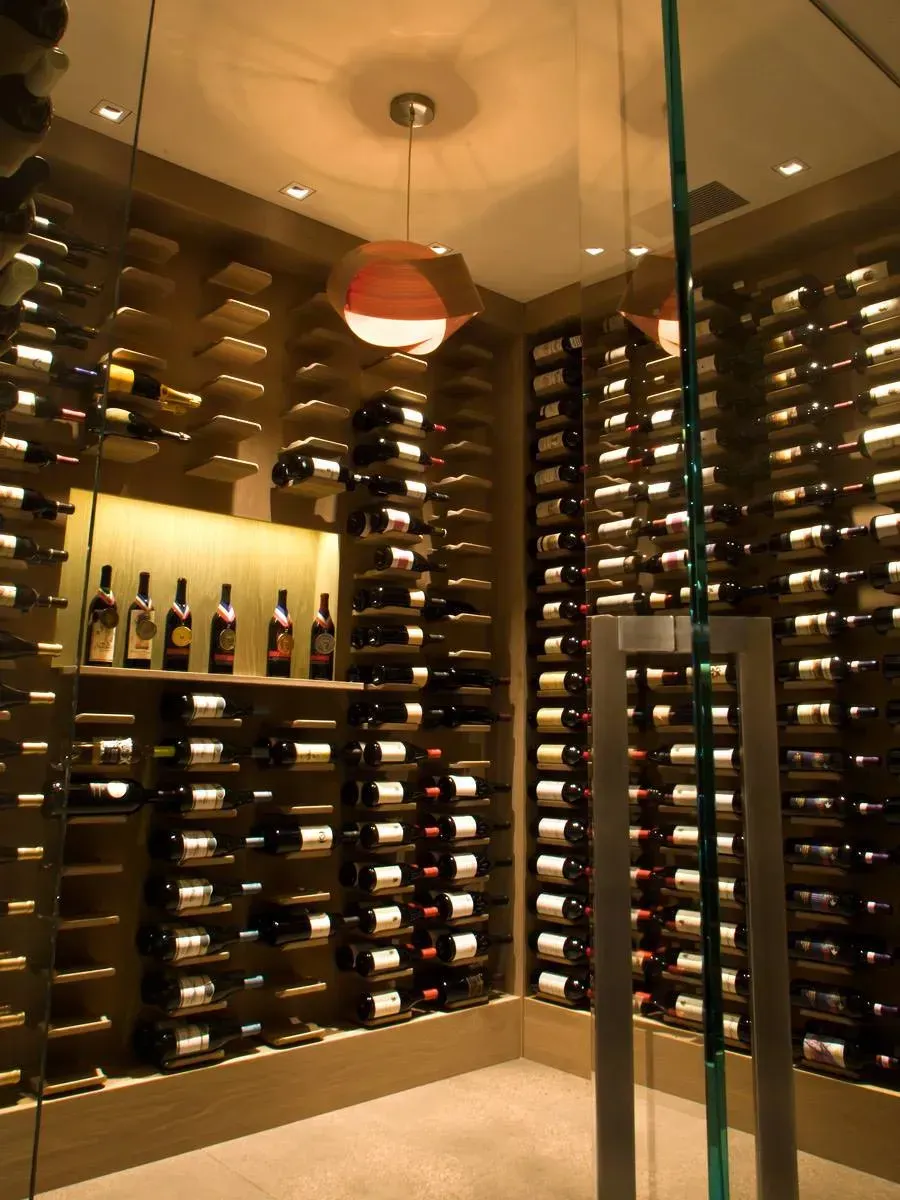Wine cellar with floor-to-ceiling bottle racks and warm pendant lighting