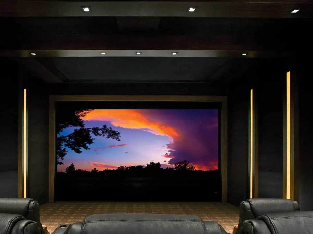 Modern home theater with a large screen showing a vivid sunset scene